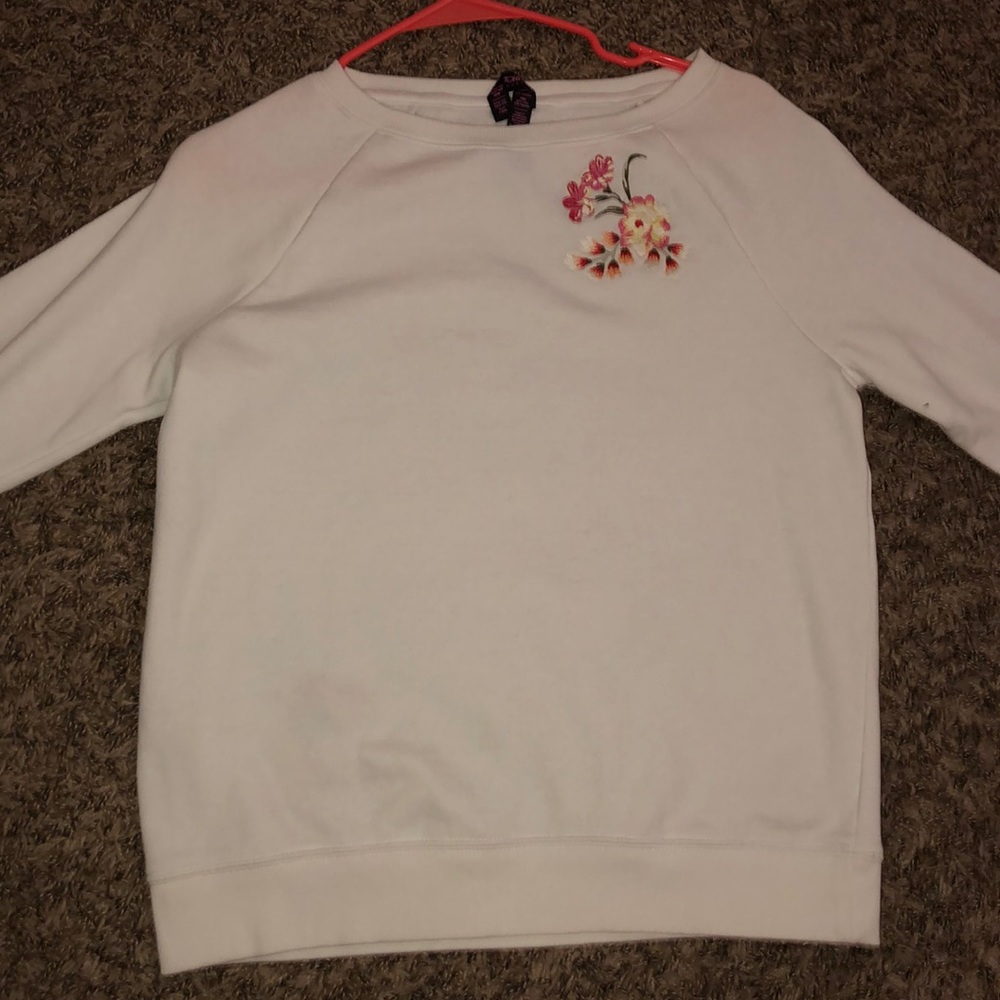 White sweater with colorful flower accents.